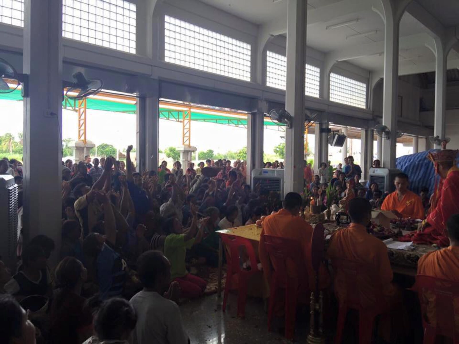 พระสงฆ์เจริญพระพุทธมนต์และให้พรชาวบ้านในโรงงานก่อนเทกระจาด