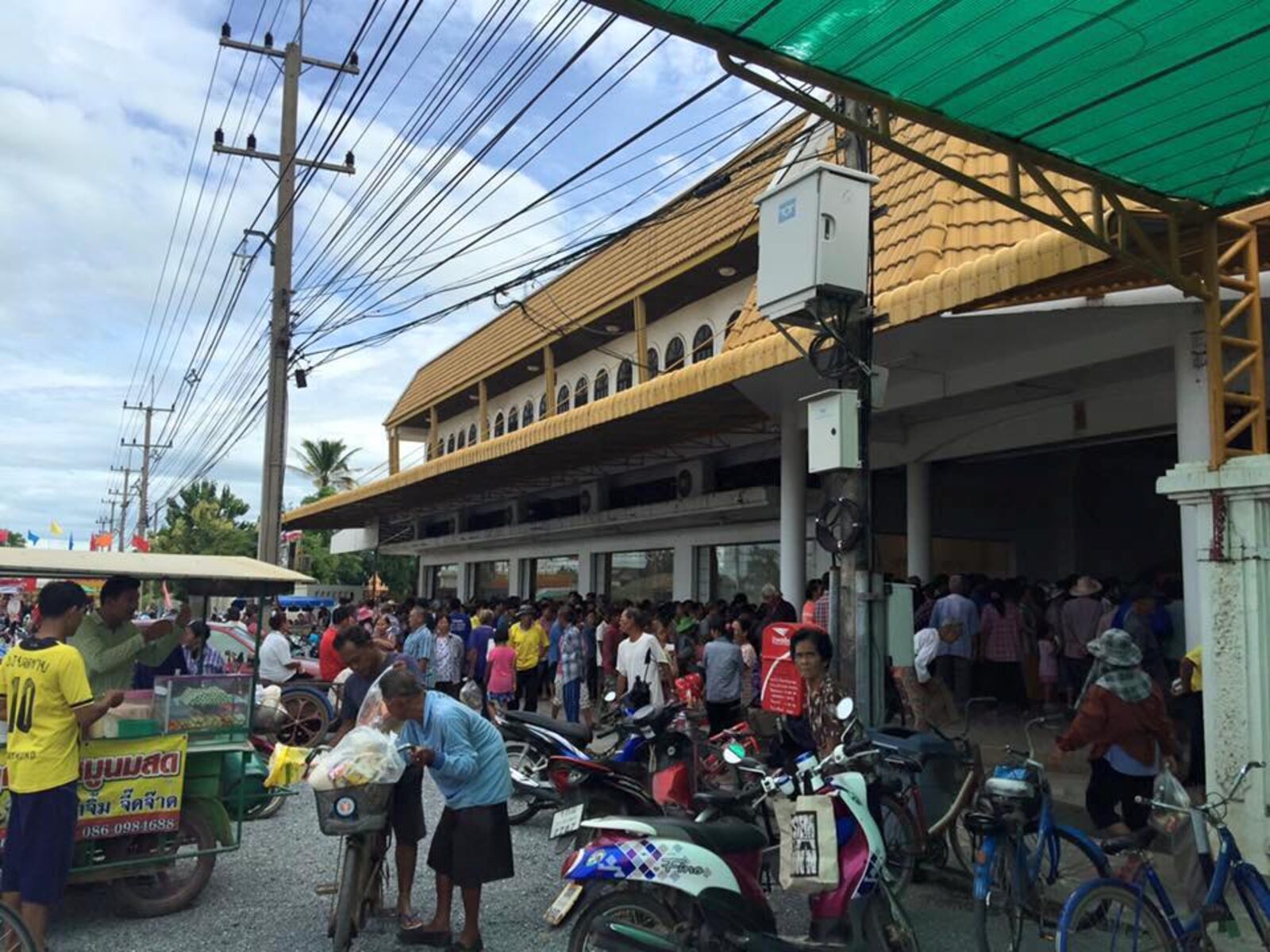 ชาวบ้านชุมชนคลองขลุงเข้าร่วมพิธีเทกระจาดในโรงงานวุ้นเส้น พระสงฆ์กำลังโปรยน้ำพระพุทธมนต์
